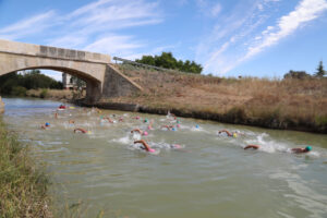 Nadadores en el Canal de Castilla bajo un puente histórico