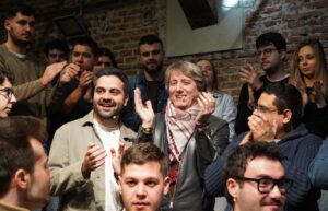 Candidatos y jóvenes aplaudiendo en un evento político