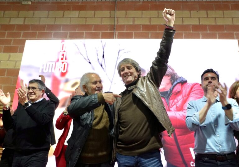 Carlos Martínez en un mitin levantando el brazo con entusiasmo
