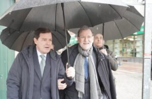 Candidatos políticos bajo paraguas durante un evento en Segovia