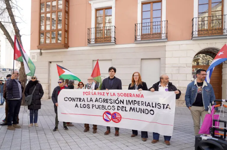 Manifestantes sosteniendo una pancarta contra la agresión imperialista