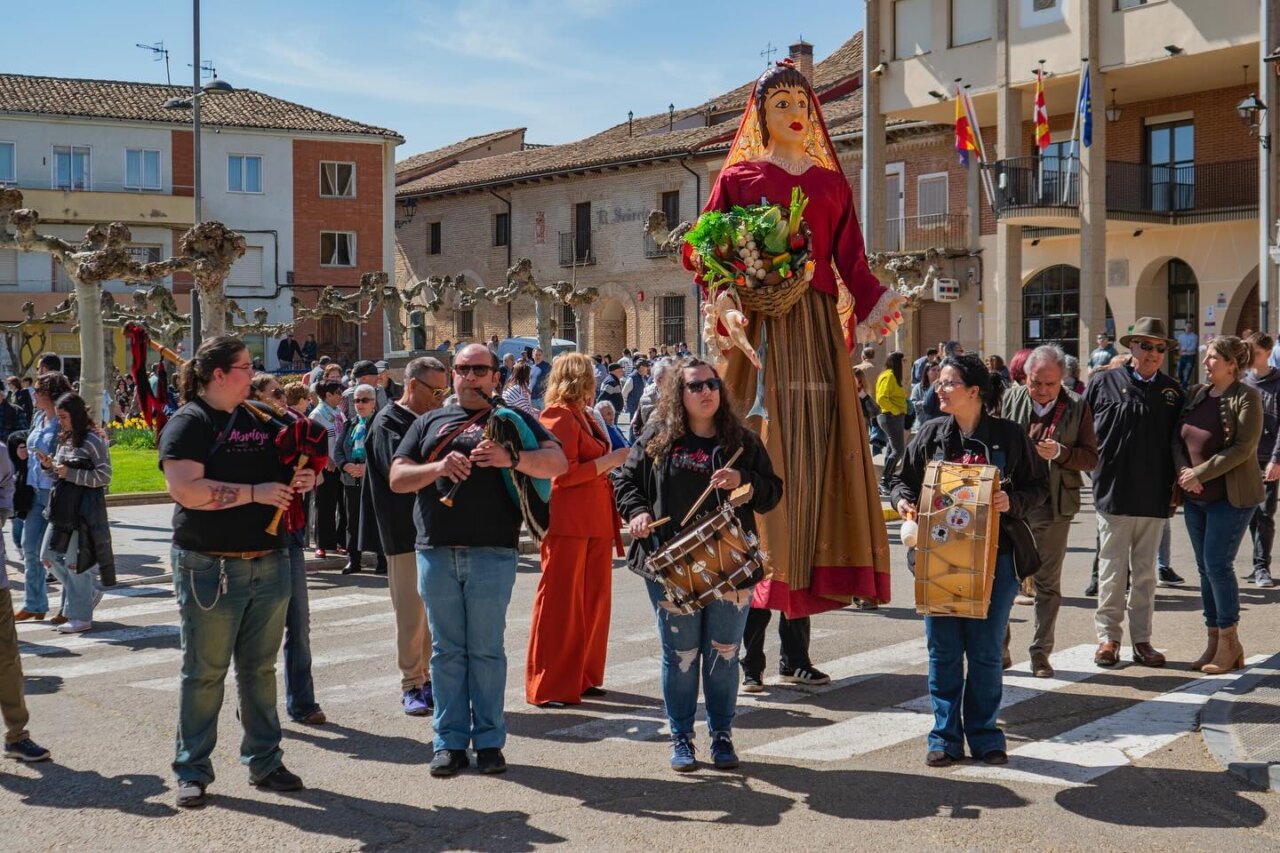Participantes en la Feria de la Matanza de Villada con instrumentos musicales y una figura gigante.
