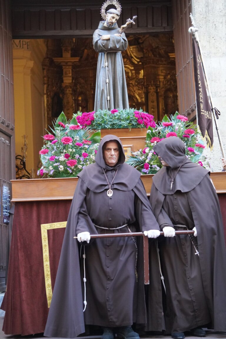Dos hombres con túnicas oscuras en una procesión religiosa en Palencia.