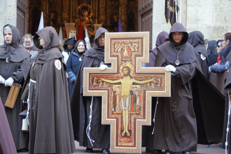 Participantes en la procesión del Sábado de Dolores en Palencia con una cruz