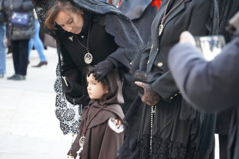 Mujer ajustando el velo de una niña en la procesión del Sábado de Dolores
