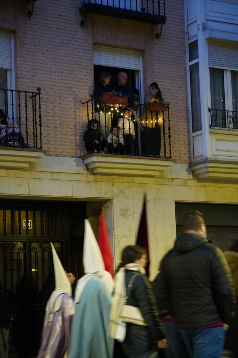 Personas observando la procesión del Sábado de Dolores desde un balcón
