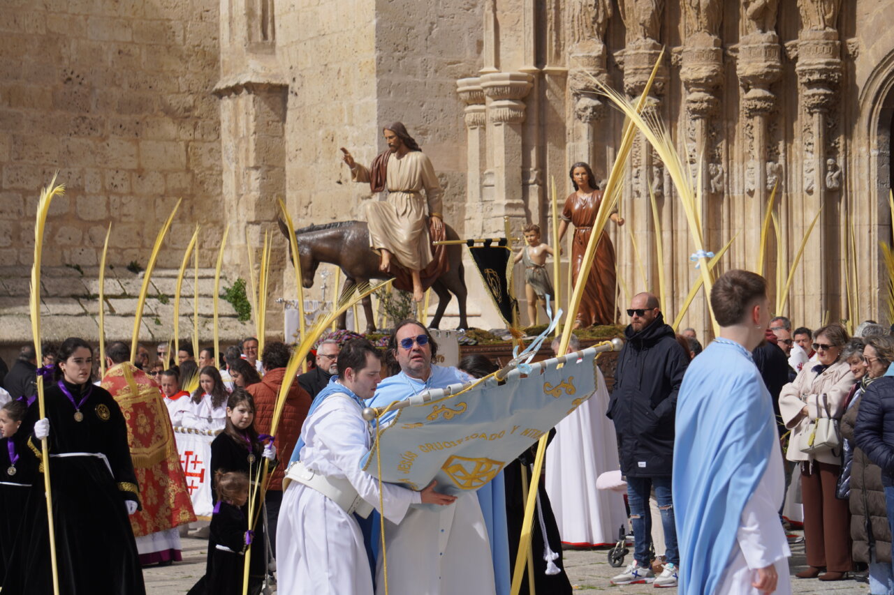 Procesión del Domingo de Ramos en Palencia con figuras religiosas y palmas.