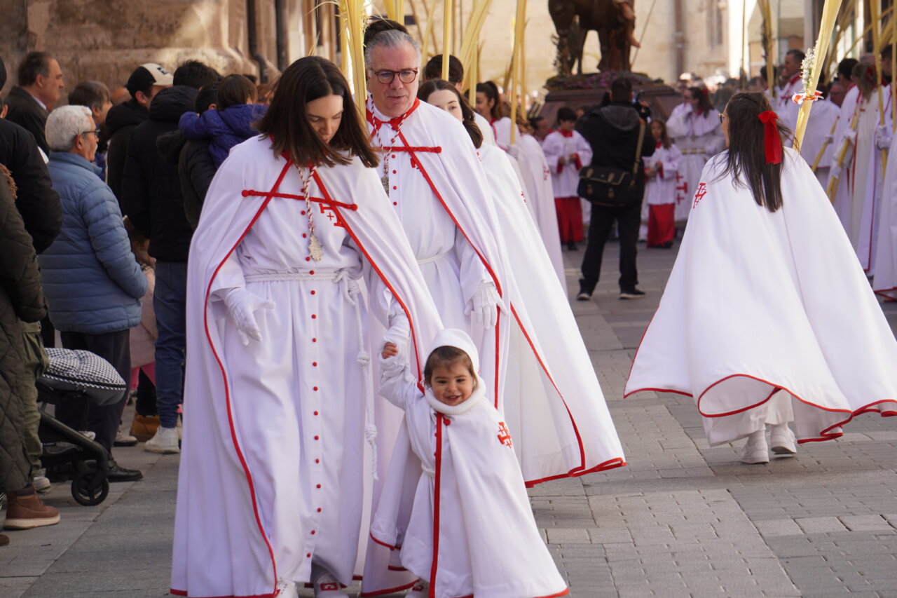 Familia en procesión de La Borriquilla en Palencia con palmas