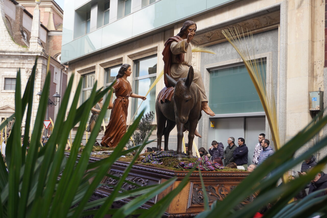 Procesión de La Borriquilla en Palencia con figuras religiosas y palmas