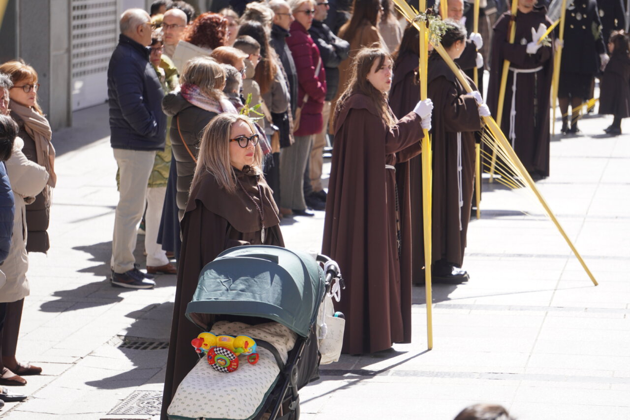 Multitud en la procesión del Domingo de Ramos en Palencia con cofrades y niños