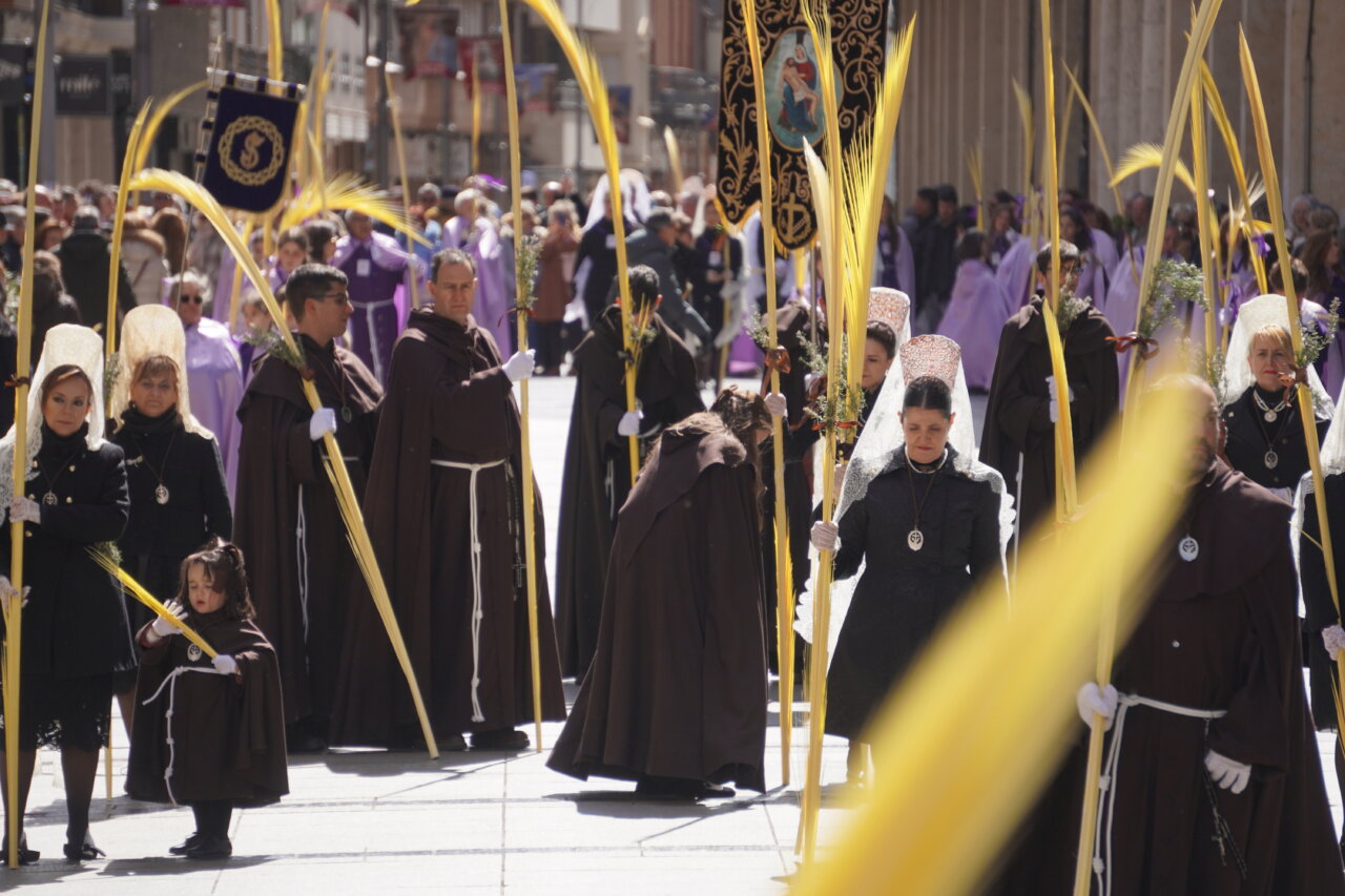 Procesión del Domingo de Ramos en Palencia con cofrades y palmas