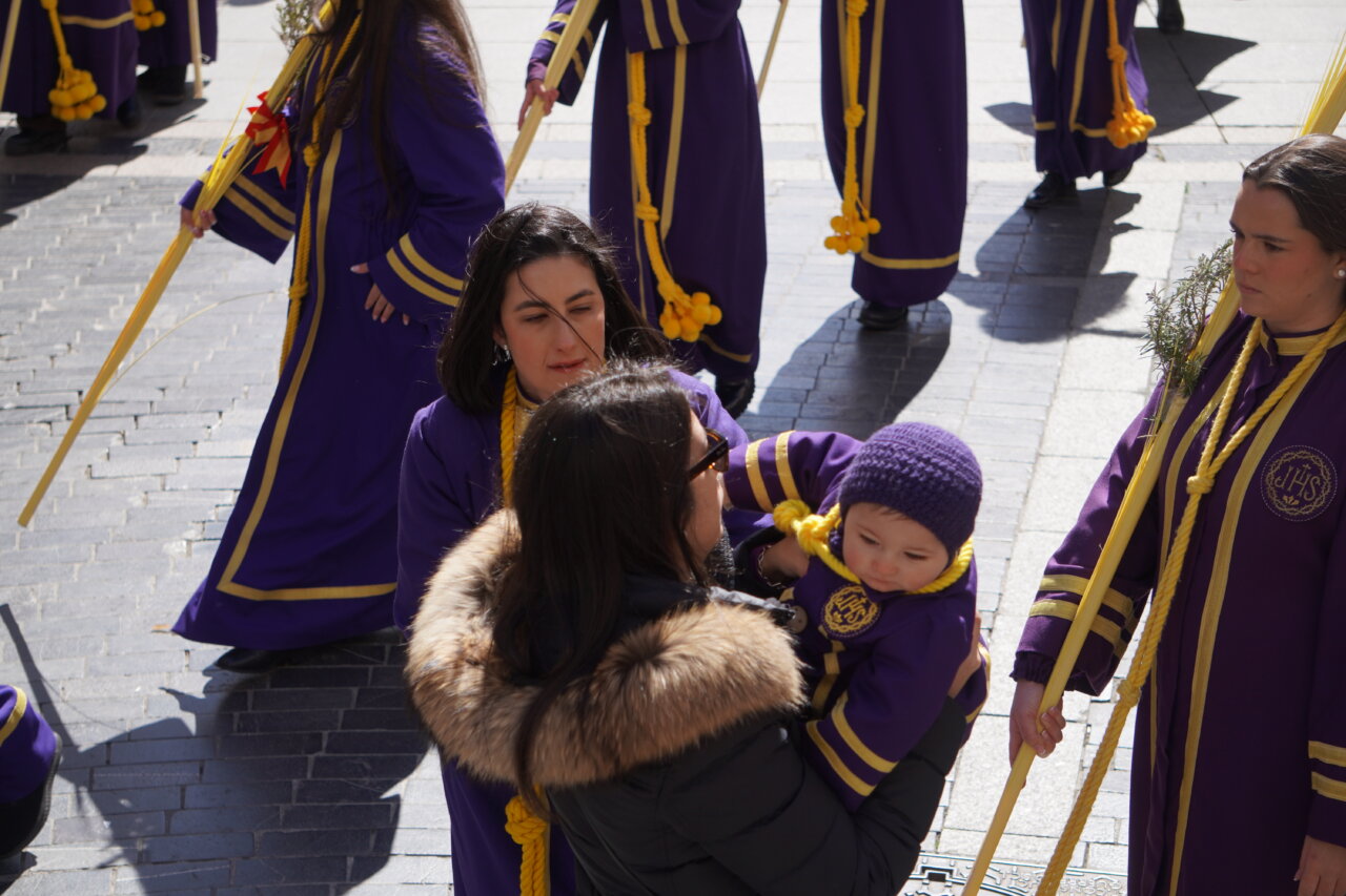 Mujeres con túnicas moradas en la procesión de La Borriquilla en Palencia