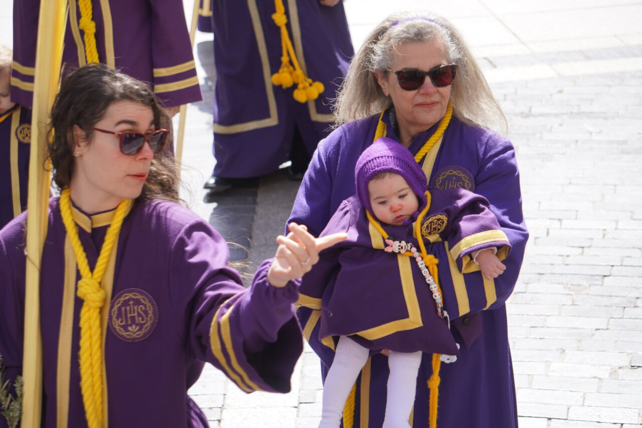 Mujeres con túnicas moradas durante la procesión de La Borriquilla en Palencia