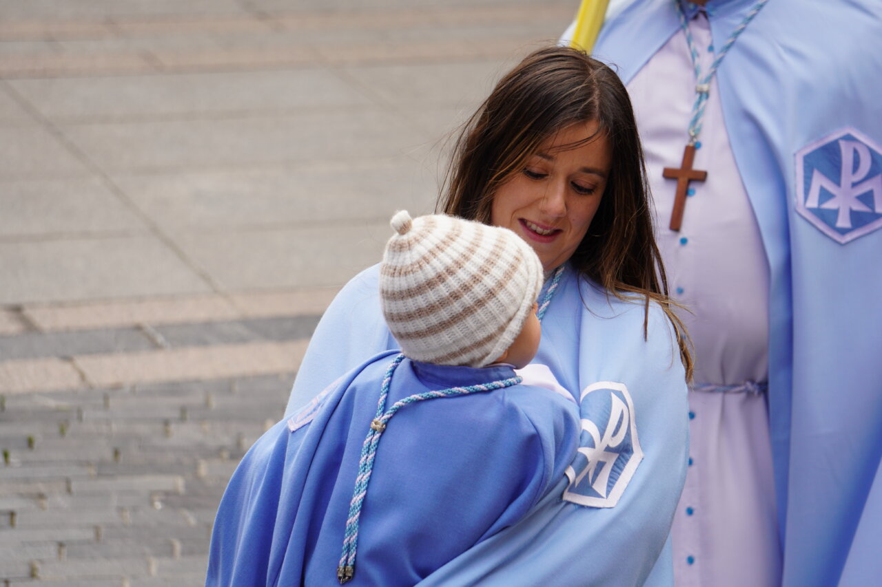 Mujer con niño en brazos durante la procesión de La Borriquilla en Palencia