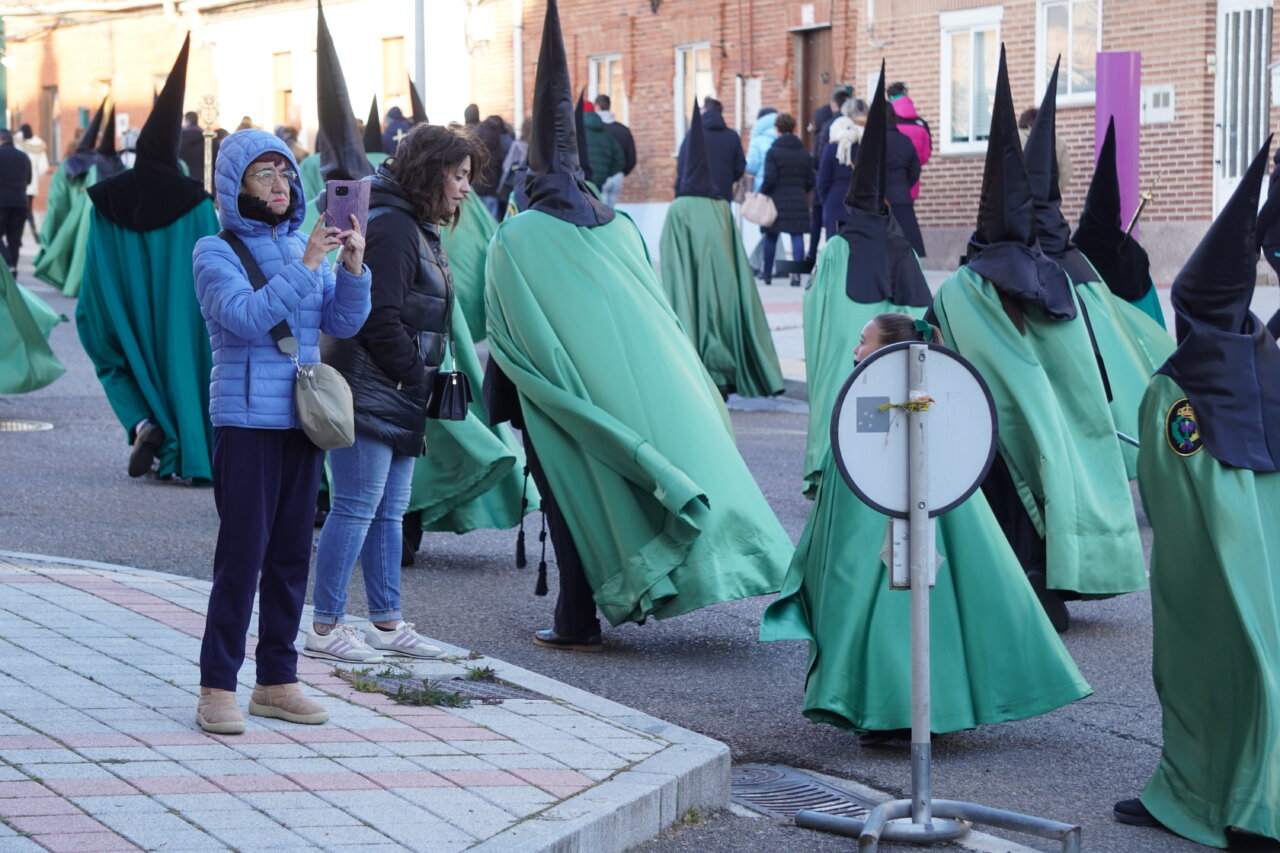 Persona tomando fotos durante la procesión del Rosario del Dolor en Palencia