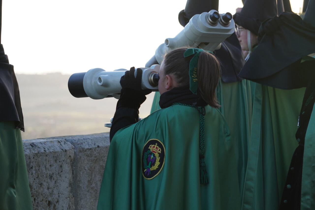 Participante de la procesión del Rosario del Dolor usando un telescopio