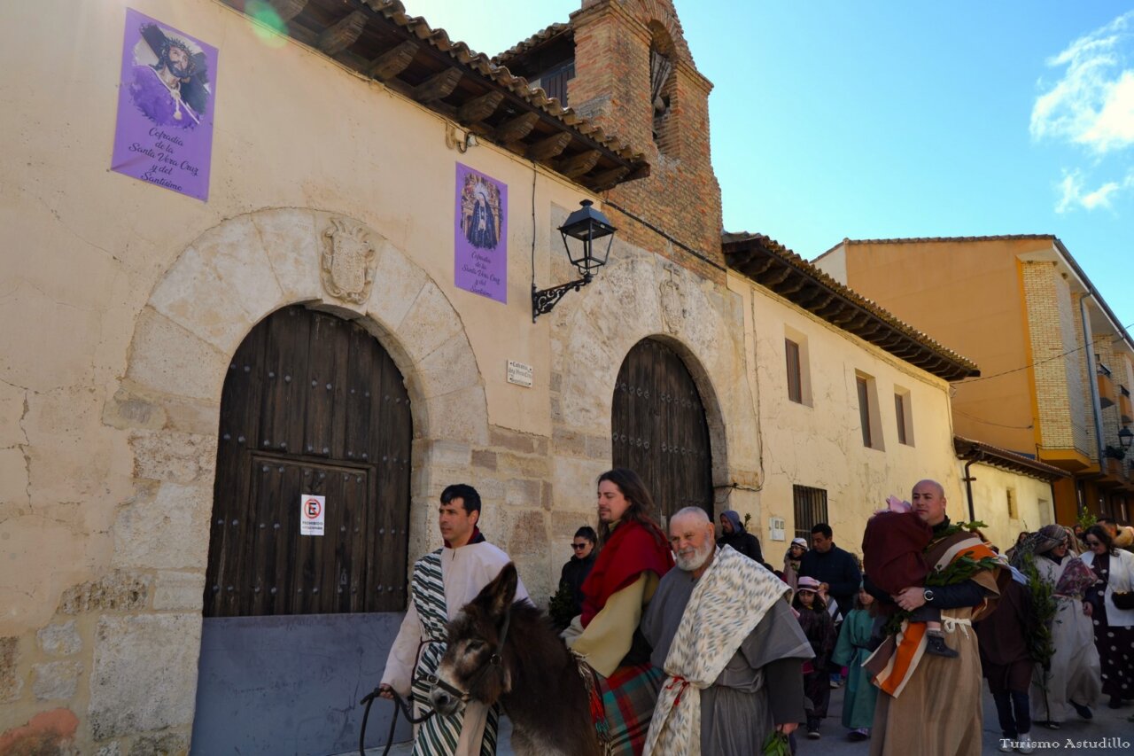 Procesión del Domingo de Ramos en Astudillo con participantes y un burro.