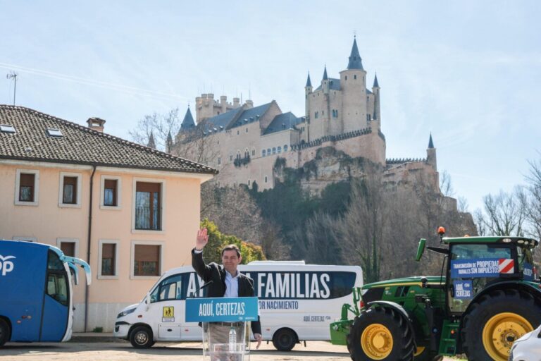 Candidato del PP en Segovia junto a vehículos y el Alcázar de fondo