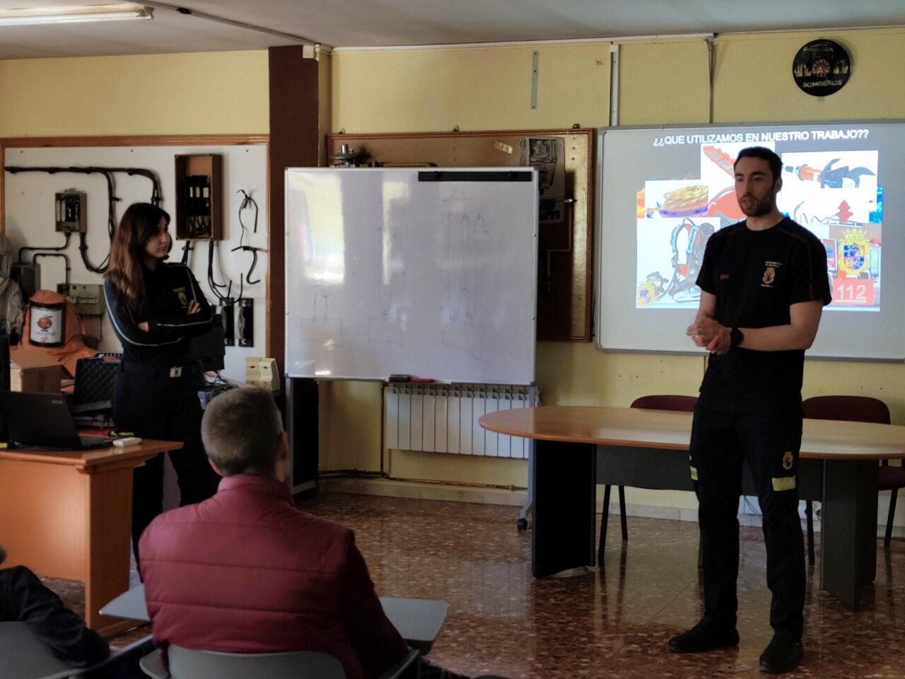 Dos bomberos explicando su trabajo durante una jornada de puertas abiertas