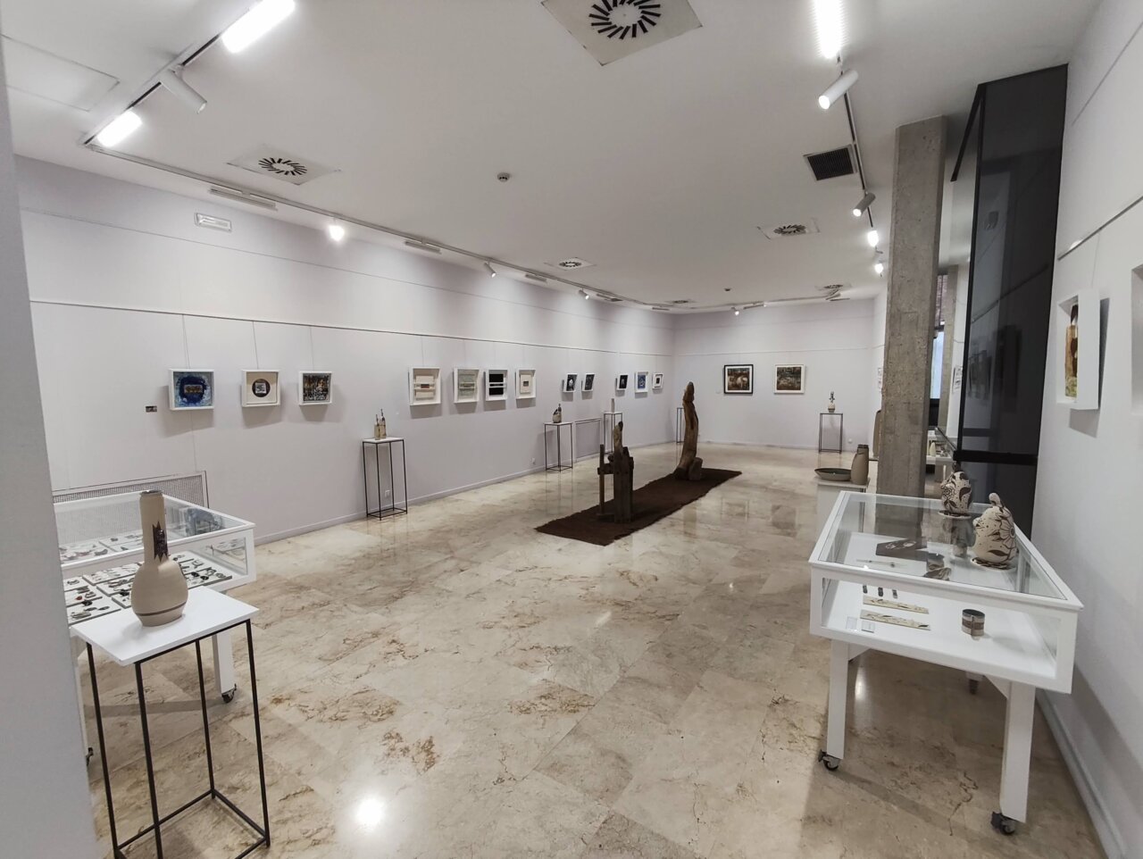 Sala de exposición con obras de ceramistas en la Biblioteca Pública