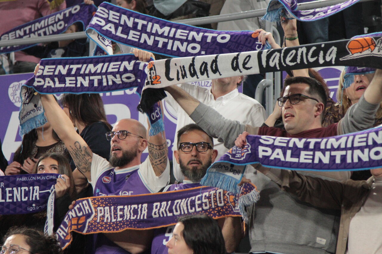 Aficionados del baloncesto animando en las gradas con bufandas