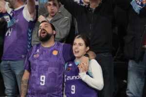 Aficionados animando en las gradas durante un partido de baloncesto