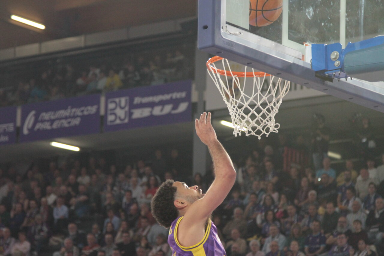 Jugador de baloncesto lanzando a canasta en un partido de Palencia