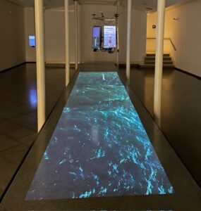 Instalación artística que proyecta imágenes de faros y agua marina