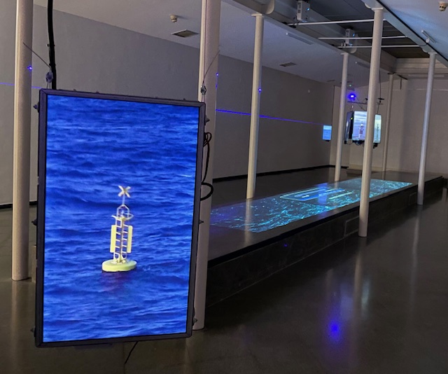 Instalación artística con imágenes de boyas en el mar y efectos visuales
