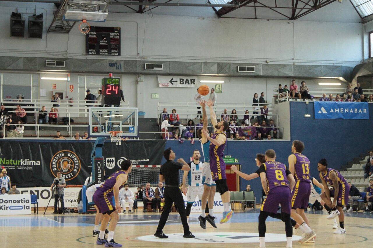 Jugadores de baloncesto saltando para el salto inicial en un partido