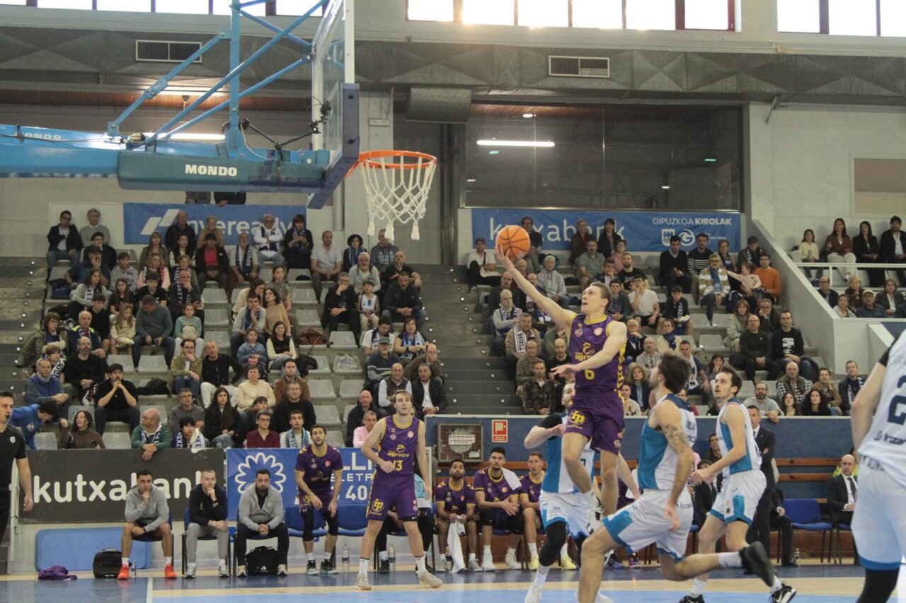 Jugador lanzando a canasta en un partido de baloncesto