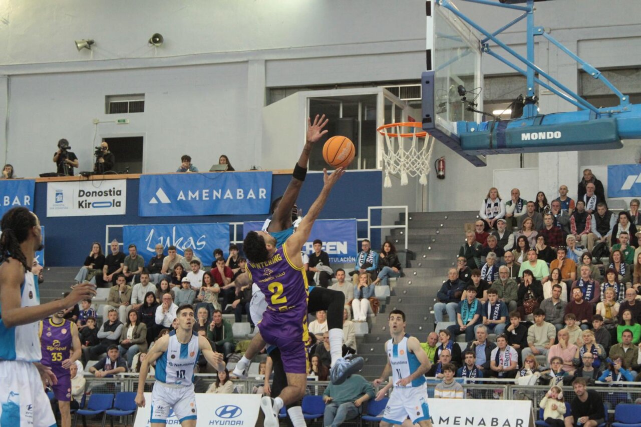 Jugador de baloncesto realizando un tiro en un partido entre Palencia y Gipuzkoa.