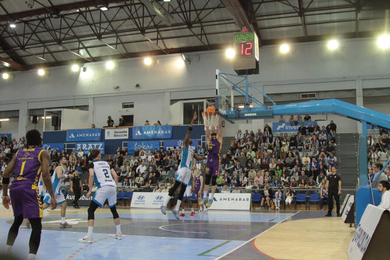 Jugador de baloncesto realizando un mate en un partido
