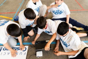 Niños participando en un torneo de robótica rural con kits educativos
