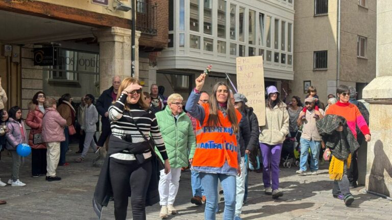 Personas marchando en la manifestación del 8M en Palencia, con pancartas y vestimenta colorida.