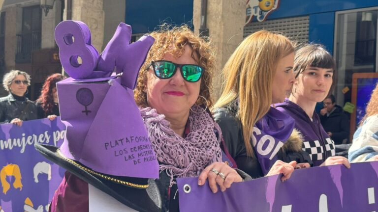 Mujeres en manifestación del 8M en Palencia con pancartas y vestimenta morada.