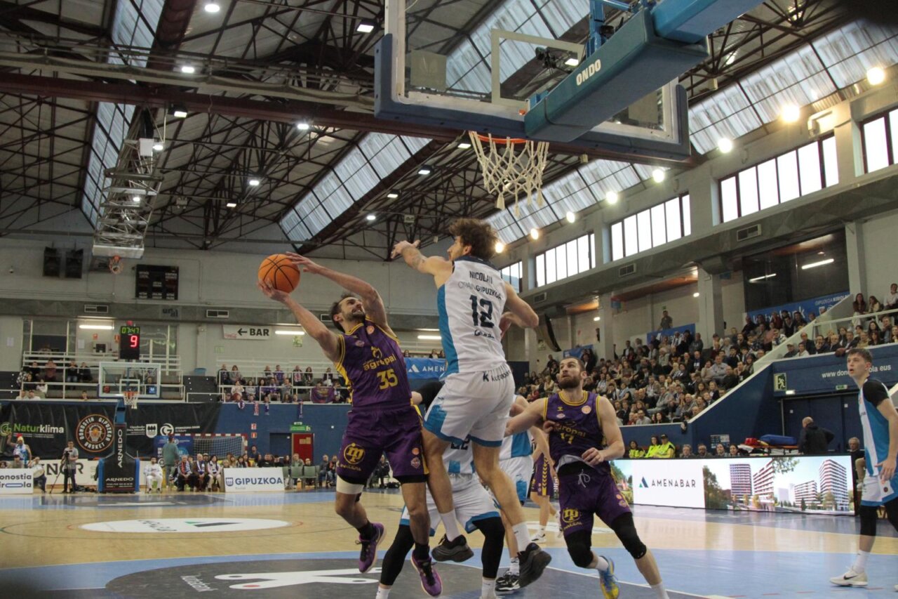 Jugador de baloncesto lanzando a canasta en un partido emocionante