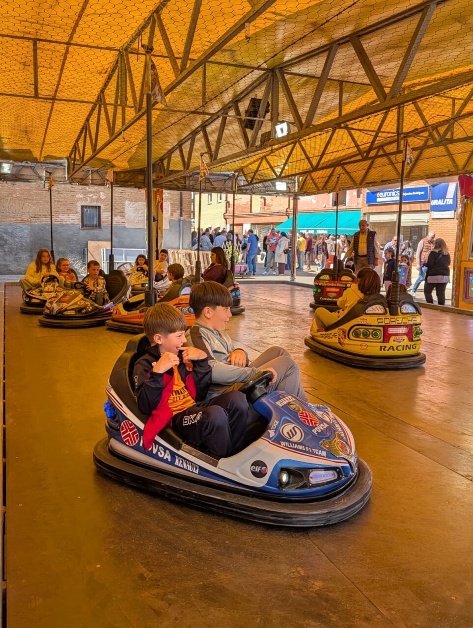 Niños disfrutando en un parque de atracciones durante la Feria de la Matanza en Villada.