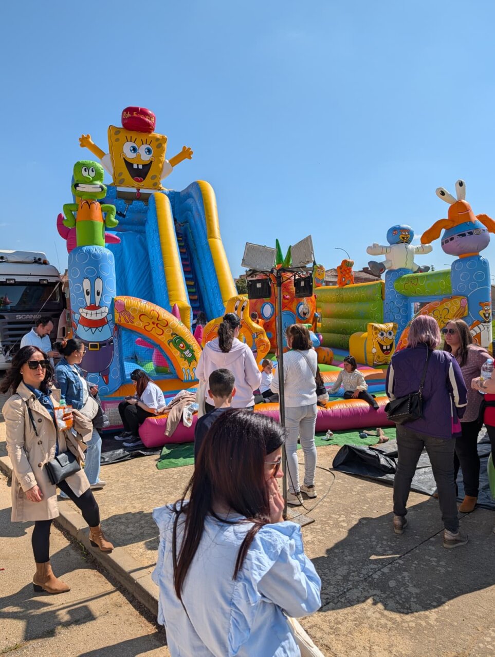 Familias disfrutando de atracciones inflables en la Feria de la Matanza en Villada