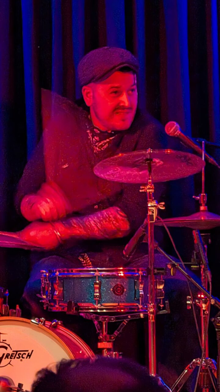 Músico tocando la batería durante un concierto en Venta de Baños