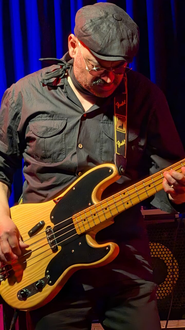 Músico tocando un bajo eléctrico en un concierto en Venta de Baños