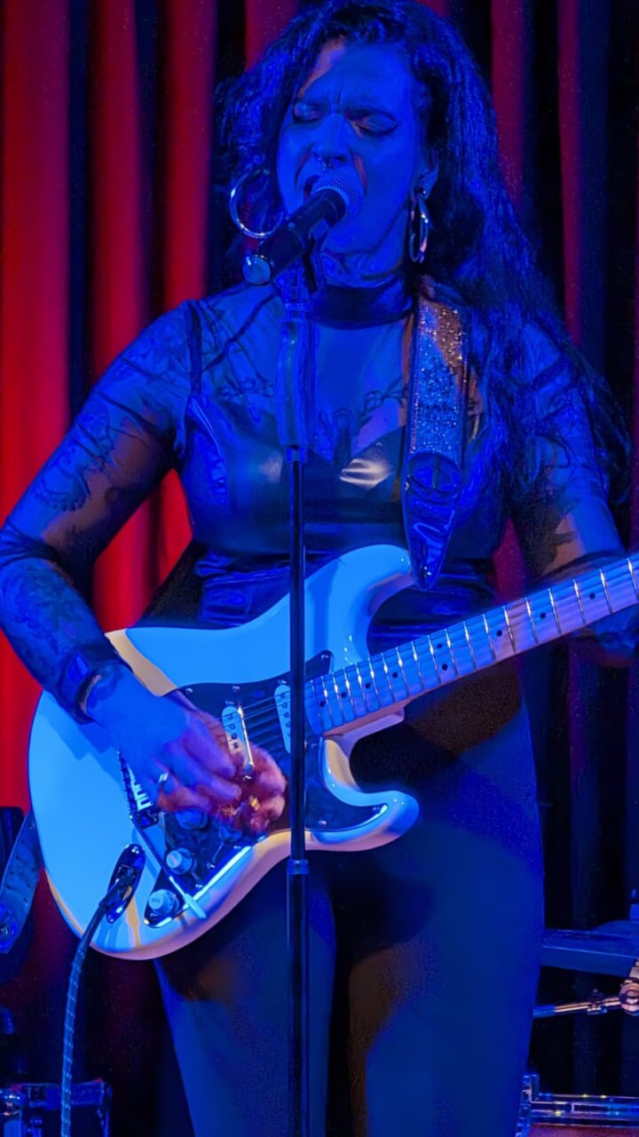 Anna Dukke cantando y tocando la guitarra en un concierto