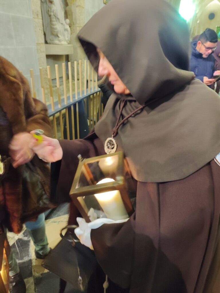 Cofrade sosteniendo una lámpara durante la procesión del Sábado de Dolores en Palencia