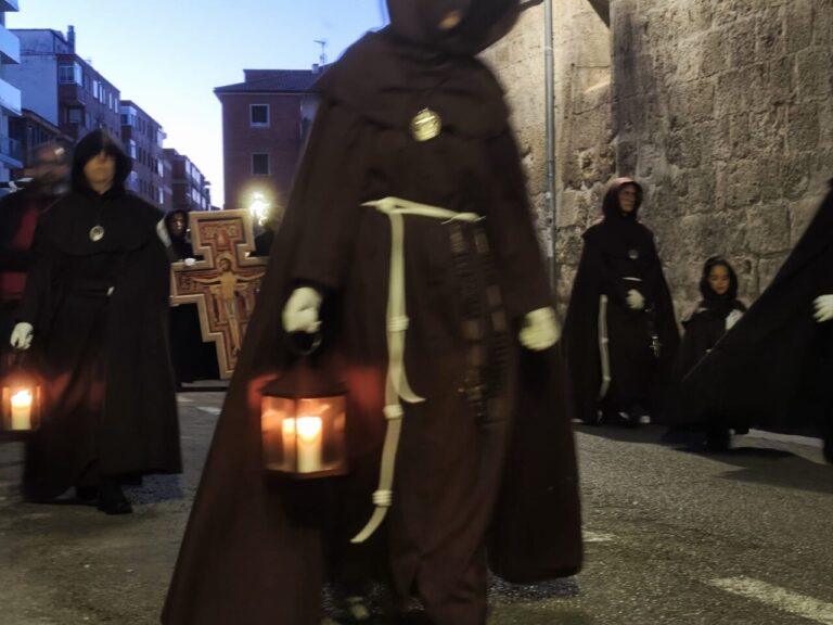 Cofrades con túnicas oscuras y faroles en una procesión
