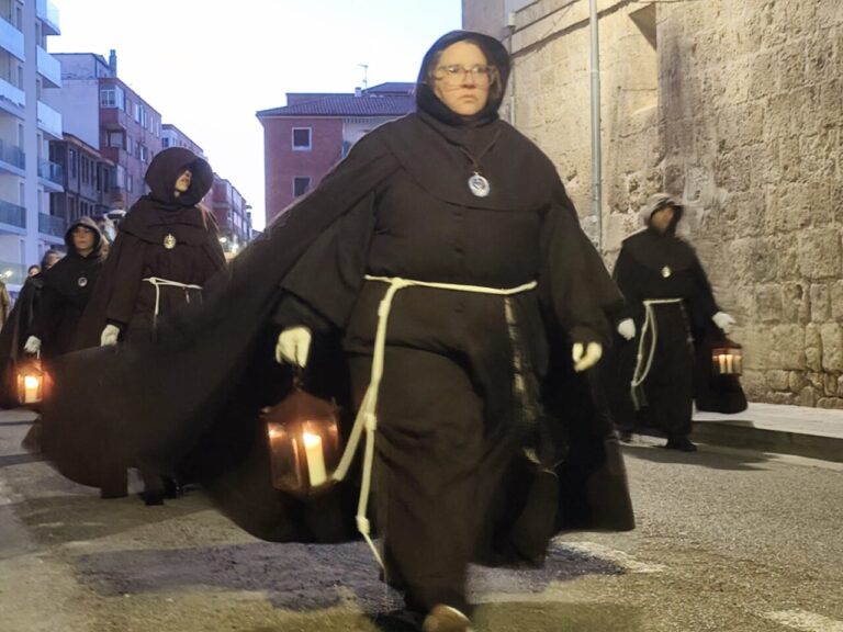 Cofrades con túnicas oscuras y faroles en la procesión del Sábado de Dolores