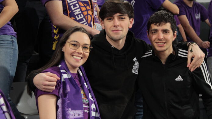 Aficionados del Palencia en un partido de baloncesto con bufandas moradas