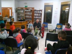 Niños escuchando a un narrador en una biblioteca