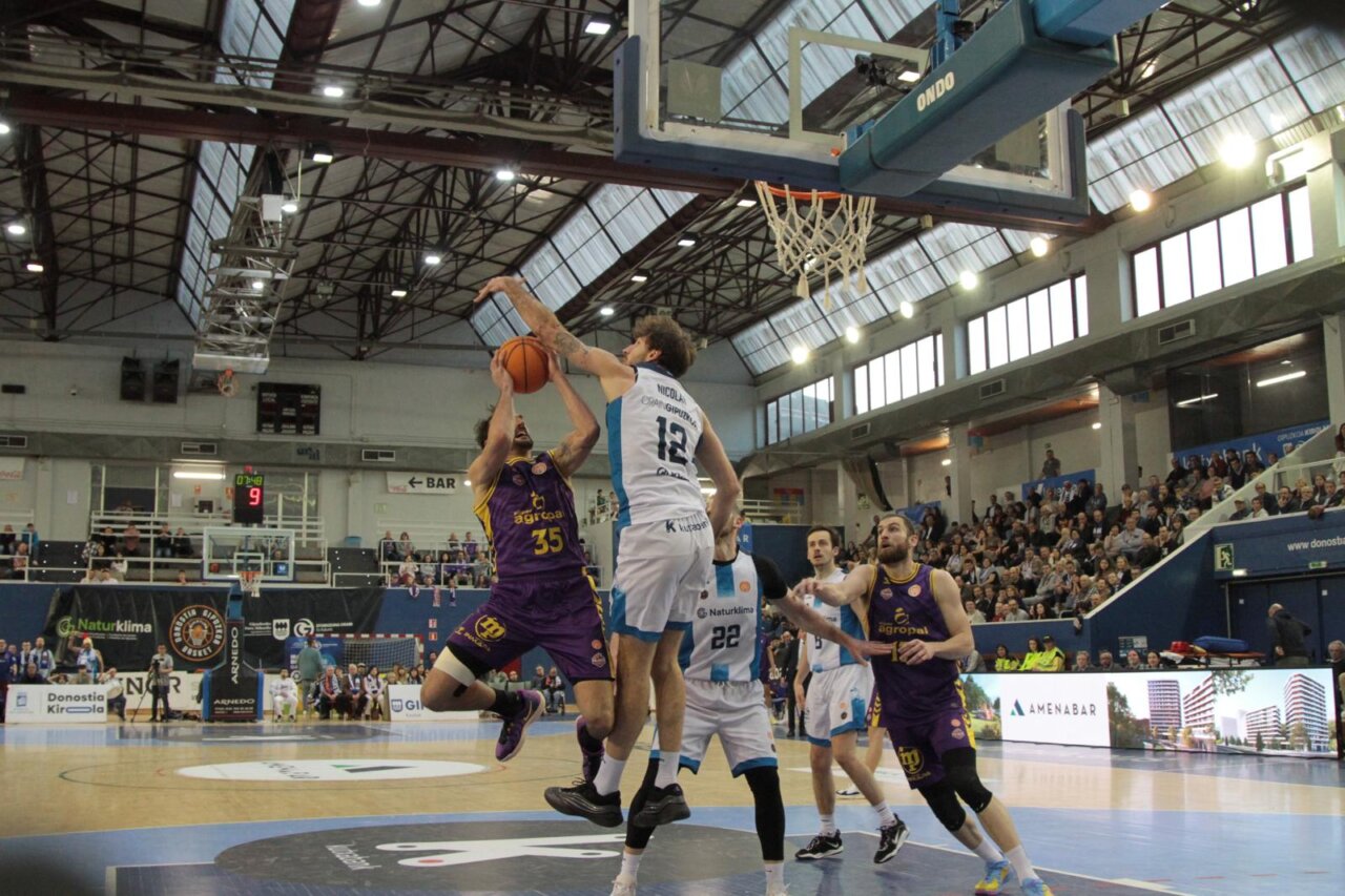 Jugador de baloncesto intentando encestar en un partido emocionante