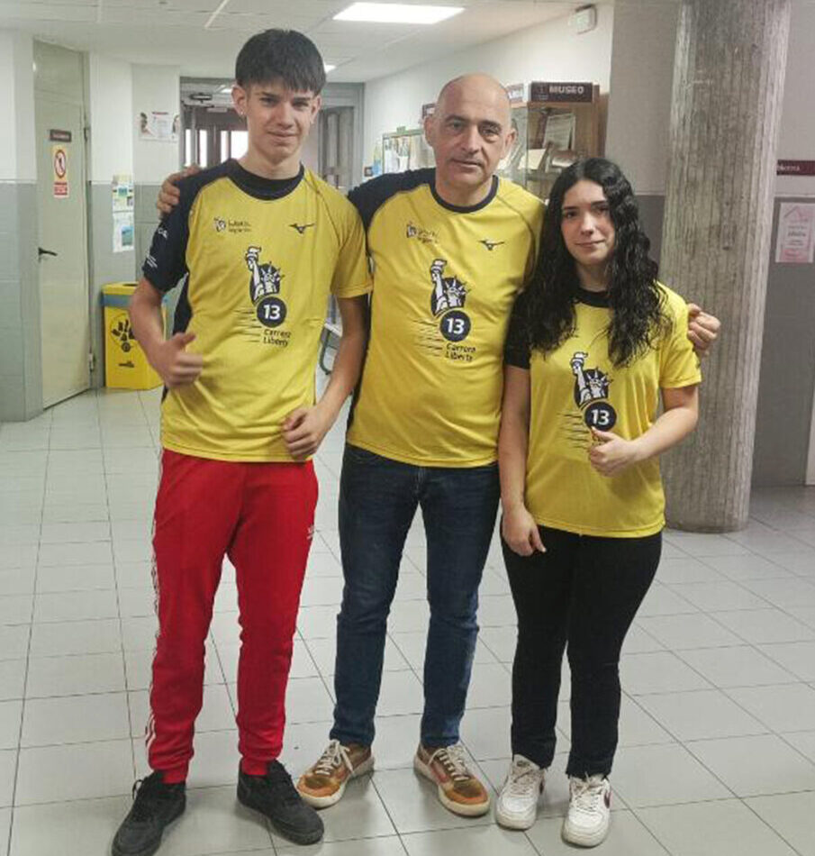Tres personas posando con camisetas de la III Carrera Solidaria y Saludable