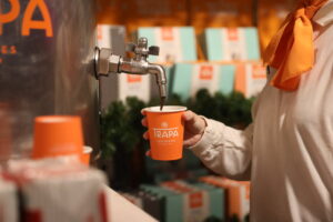 Persona sirviendo chocolate caliente en evento de Trapa